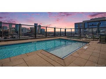 Rooftop pool with stunning city skyline view and lounge seating at sunset at 1750 Wewatta St # 728, Denver, CO 80202