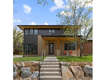 Modern home with a well-manicured lawn, natural stone accents, and a welcoming covered porch at 1100 S Elizabeth St, Denver, CO 80210