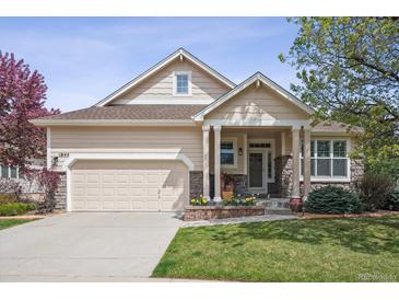 Charming single-Gathering home featuring a well-manicured lawn, two-car garage, and inviting covered front porch at 1844 S Jay Way, Lakewood, CO 80232