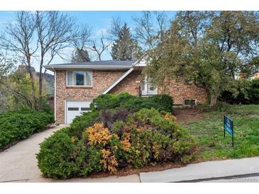 Charming brick home with an attached garage, mature landscaping, and a well-maintained front yard at 2015 Arapahoe St, Golden, CO 80401