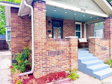 Charming brick home with a covered front porch, a swing, string lights, and newly painted steps at 2731 S Logan St, Englewood, CO 80113