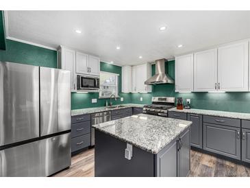 Modern kitchen features stainless steel appliances, gray cabinets, granite countertops, and a center island at 2650 S Vaughn Way # D, Aurora, CO 80014