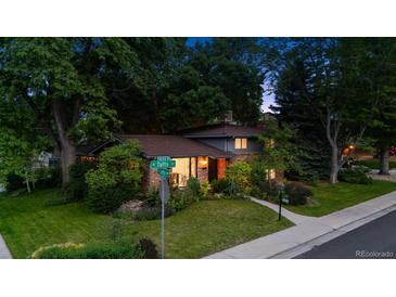 Charming two-story brick home with mature landscaping and a well-maintained front yard in a quiet neighborhood at 4634 W Tufts Cir, Denver, CO 80236