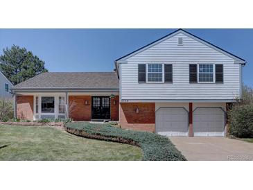 Charming home featuring a well-manicured lawn, brick accents, and an attached two-car garage at 5759 E Geddes Cir, Centennial, CO 80112
