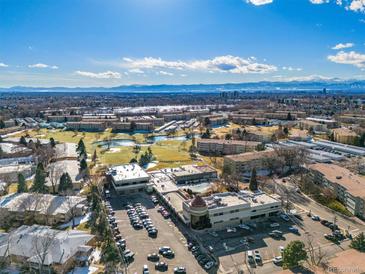 Expansive aerial view of a community featuring mature trees, green spaces, and distant mountain views under a clear blue sky at 750 S Clinton St # 6B, Denver, CO 80247