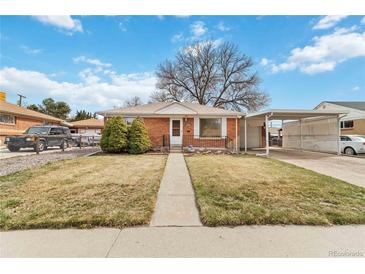 Charming brick home featuring a well-maintained front yard and a convenient carport at 6900 Avrum Dr, Denver, CO 80221