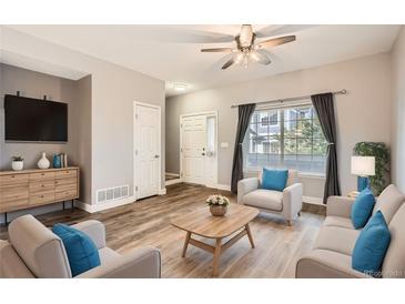 Bright living room with hardwood floors, neutral walls, and comfy seating at 19249 E Carolina Dr # 106, Aurora, CO 80017