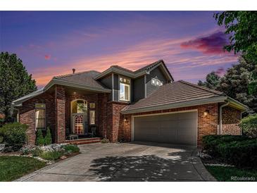 Beautiful home with brick and gray siding, a tile roof, and mature landscaping, perfect for curb appeal at 6500 W Mansfield Ave # 39, Denver, CO 80235