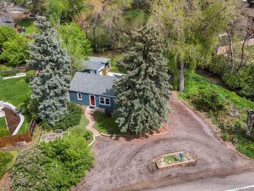 Charming single-story home boasts mature trees and a cozy, welcoming curb appeal at 1580 Youngfield St, Lakewood, CO 80215