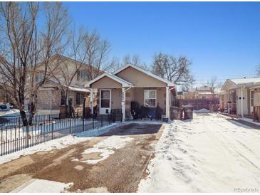 Tan house with snowy yard and black fence at 4982 W Kentucky Ave, Denver, CO 80219