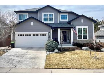 Charming two-story home featuring a gray exterior, white trim, attached garage, and well-manicured front yard at 9925 Keenan St, Highlands Ranch, CO 80130