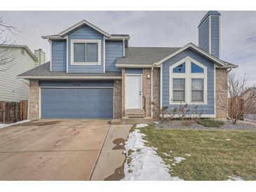 Two-story house with blue siding, attached garage, and a landscaped yard at 4334 Liverpool Ct, Denver, CO 80249