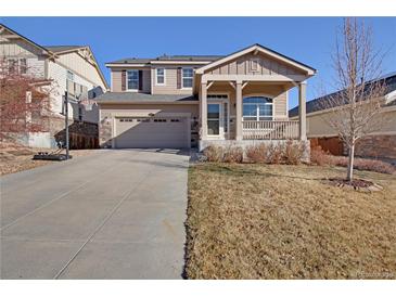 Charming two-story home featuring a covered front porch, landscaped yard, and a two car garage at 24317 E Powers Ave, Aurora, CO 80016