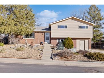 Charming brick and vinyl two-story home with a well-maintained front yard and mature trees at 10826 Livingston Dr, Northglenn, CO 80234