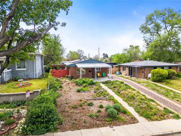 Charming bungalow with xeriscaped front yard and cozy covered porch with vibrant yellow and green chairs at 3015 N Fillmore St, Denver, CO 80205