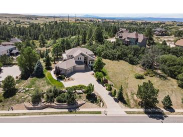 Expansive property showcasing lush landscaping, mature trees, and a sprawling driveway leading to a grand home at 6398 Lost Canyon Ranch Rd, Castle Rock, CO 80104