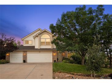 Charming two-story home with a well-maintained lawn, mature trees, and a three-car garage at 7158 Torrey St, Arvada, CO 80007