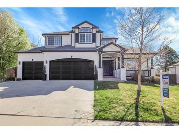Elegant two-story home boasts a three-car garage and a beautifully landscaped front yard at 6424 S Routt St, Littleton, CO 80127