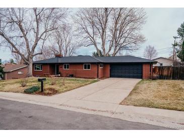 Charming brick ranch-style home featuring a well-maintained lawn and attached two-car garage at 3400 Moore St, Wheat Ridge, CO 80033