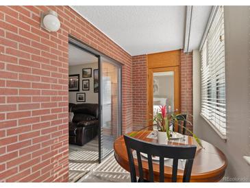 Balcony features a small dining table and access to the living room via sliding glass doors at 534 E 7Th Ave # 206, Denver, CO 80203