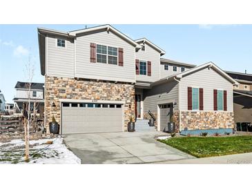 Two-story house with stone accents and a two-car garage at 6307 E 141St Ln, Thornton, CO 80602