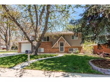 Charming two-story home featuring a well-manicured lawn and mature trees in a quiet neighborhood at 5898 Parfet Ct, Arvada, CO 80004