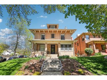 Charming brick home with a welcoming front porch and landscaped front yard on a sunny day at 1176 Gaylord St # 101, Denver, CO 80206