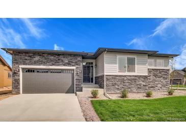 Beautiful single-story home featuring stone accents, a two-car garage, and a well-maintained front lawn at 15993 E 112 Pl, Commerce City, CO 80022