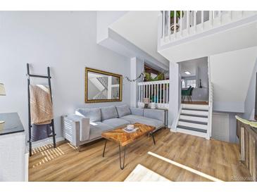 Cozy living room featuring a comfortable sectional couch, wood floors, and decorative accents at 1885 S Quebec Way # J106, Denver, CO 80231