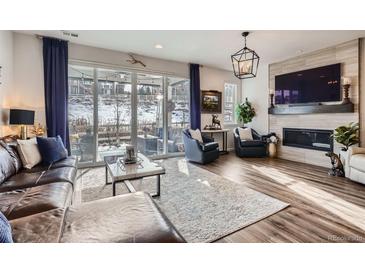 Sun-drenched living room with a fireplace, hardwood floors and patio access at 1784 Cade Ave, Castle Rock, CO 80104