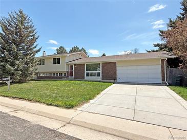 Charming single-Gathering home featuring a brick facade, well-manicured lawn, and an attached two-car garage at 1822 Ura Ln, Northglenn, CO 80234