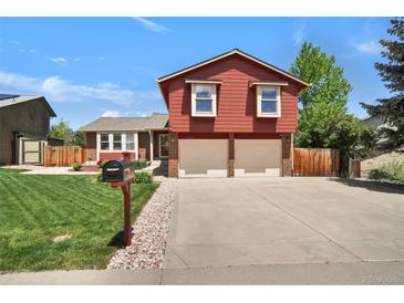 Charming red split-level home with an attached two-car garage and well-maintained front lawn at 8065 W Fremont Dr, Littleton, CO 80128