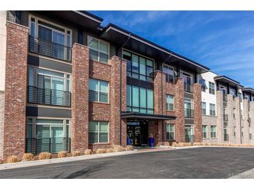 Modern brick apartment building with large windows and black trim under a blue sky at 155 S Monaco Street Pkwy # 311, Denver, CO 80224