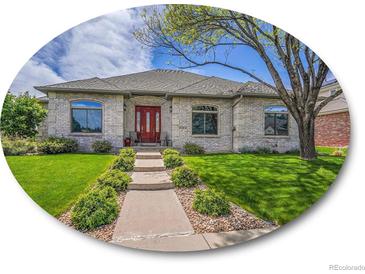 Charming home with a well-manicured lawn, stone facade, and a welcoming red front door at 4704 W Hinsdale Ct, Littleton, CO 80128