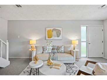Bright living room featuring neutral tones, stylish decor, and natural light from the nearby entry door at 1250 S Monaco Pkwy # 50, Denver, CO 80224