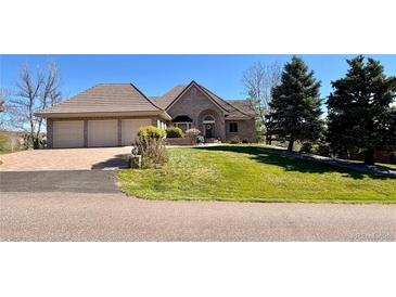 Charming brick home boasts a three-car garage and a well-manicured lawn at 5 Catamount Ln, Littleton, CO 80127