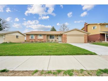 Charming ranch-style home boasts a well-manicured lawn, inviting curb appeal, and an attached two-car garage at 490 Potomac Way, Aurora, CO 80012