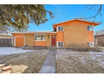 Charming orange brick home featuring a red front door and well-maintained yard at 3164 Scranton St, Aurora, CO 80011