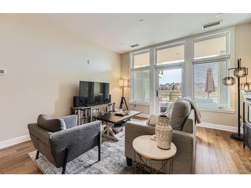 Bright living room featuring hardwood floors, large windows, and comfortable modern furnishings at 7220 W Bonfils Ln # 206, Lakewood, CO 80226
