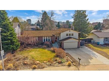 Charming two-story home featuring a brick facade, attached garage, and a well-maintained lawn at 8690 E Chenango Ave, Denver, CO 80237