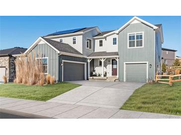 Two-story farmhouse with gray siding, attached garage, and landscaped lawn at 4911 Colorado River Dr, Firestone, CO 80504