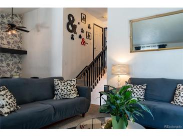 Cozy living room featuring stylish decor, comfortable seating, and a staircase leading to the upper level at 19044 E 16Th Ave, Aurora, CO 80011