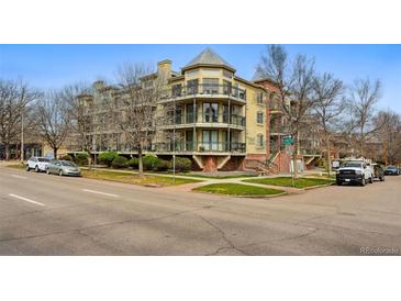 Charming multi-story condo building featuring balconies, brick accents, and lush landscaping at 1705 Gaylord St # 201, Denver, CO 80206