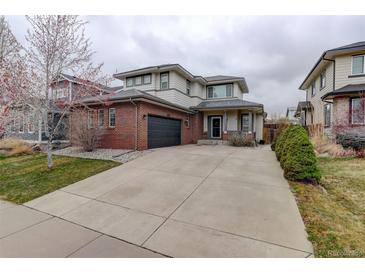 Inviting two-story home with a brick facade and a spacious driveway leading to the attached garage at 637 Millet Cir, Brighton, CO 80601