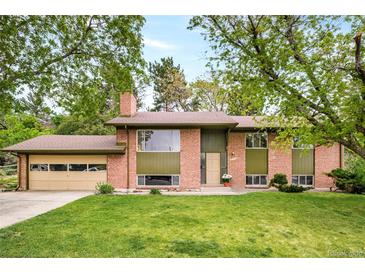 Charming brick home with a two-car garage and a well-manicured lawn surrounded by mature trees at 12193 W New Mexico Pl, Lakewood, CO 80228
