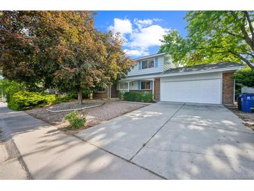 Charming two-story home featuring a well-manicured lawn, mature trees, and a spacious driveway at 4474 S Vrain St, Denver, CO 80236