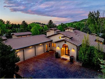 Stunning home featuring a terracotta-colored roof, attached garage, and well-manicured front yard, perfect for luxurious living at 5904 Meadowbrook Dr, Morrison, CO 80465
