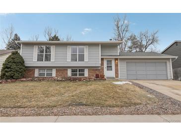 Gray ranch house with brick accents, attached garage, and a landscaped yard at 1204 Balmora St, Lafayette, CO 80026