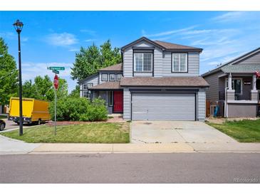 Charming two-story home boasts a well-manicured lawn, gray siding, and an attached two-car garage at 8791 Starwood Ln, Parker, CO 80134
