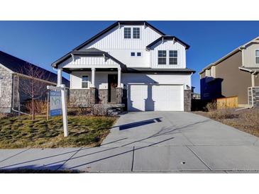 Charming two-story home boasting a modern design, stone accents, and a well-manicured front yard at 16357 E 111Th Pl, Commerce City, CO 80022